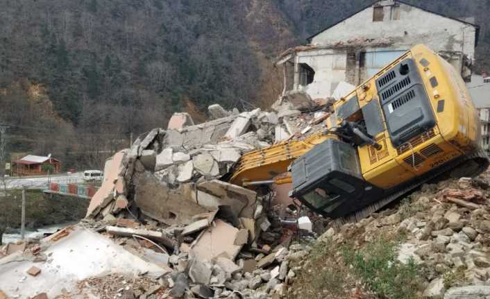 Trabzon’un Çaykara ilçesinde yıkım çalışmaları yapılan bir bina kepçenin üzerine
