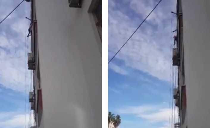 Adana’da bir apartmanın dış cephesini boyayan bir kişi çalıştığı iskelenin