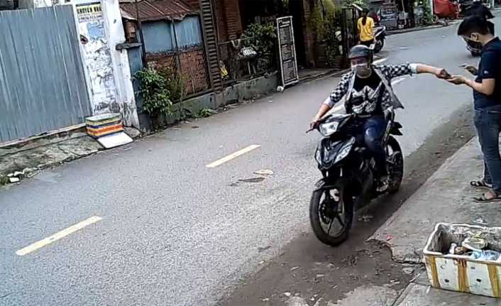 Vietnam’da otobüs durağında cep telefonuyla uğraşan genç, kapkaç mağduru oldu.