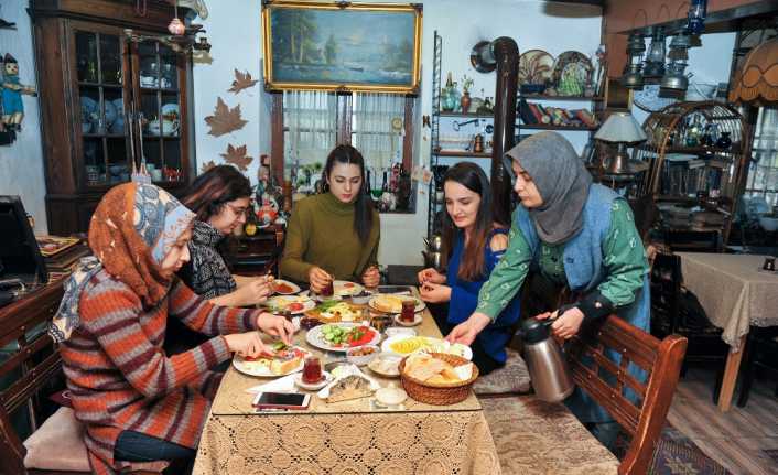 Kafede, üzerinde yılların izini taşıyan kitap, radyo, telefon, fotoğraf makinesi,