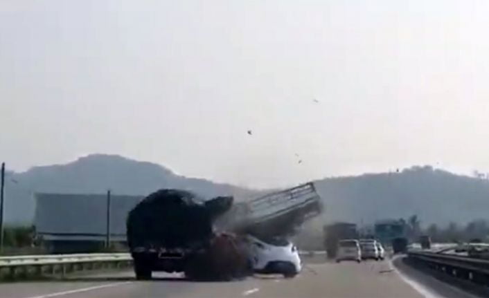 Malezya’da bir otomobil, karayolunda önünde seyreden yumurta yüklü kamyonu geçtiği