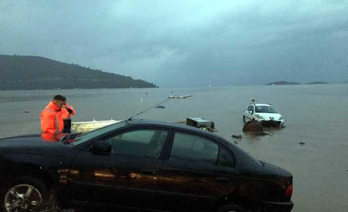 Muğla’nın Bodrum ilçesinde aşırı yağıştan korunmak için bindikleri araçlarıyla birlikte