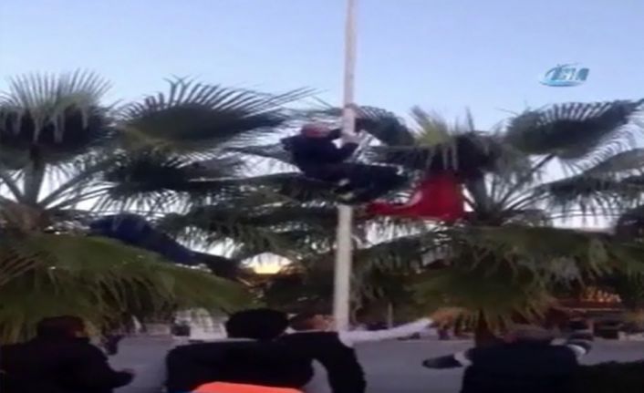 Antalya’nın Alanya ilçesinde Türk bayrağını indirmek için direğe tırmanan bir